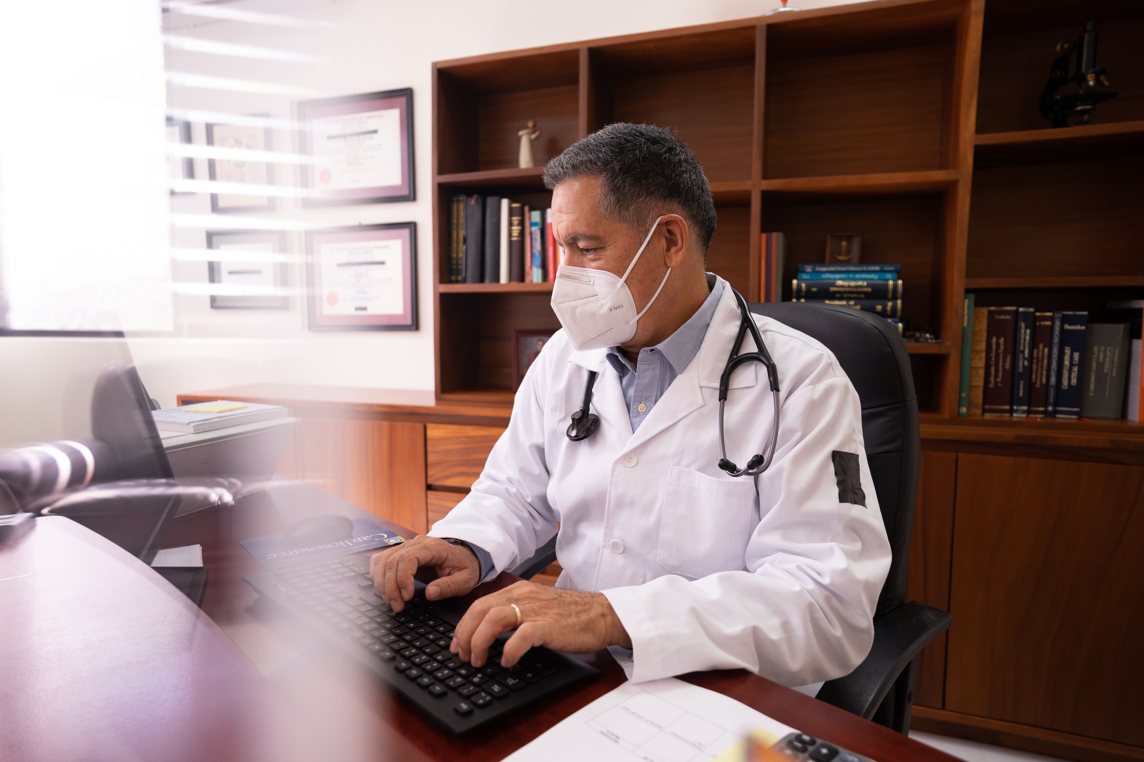 Doctor sitting at desk, typing